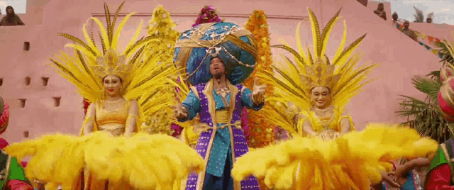 a group of people dressed in colorful costumes are standing in front of a pink building .