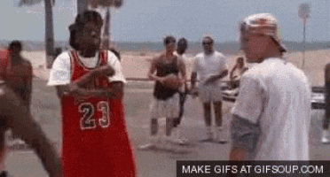 a group of young men are playing basketball on a street .