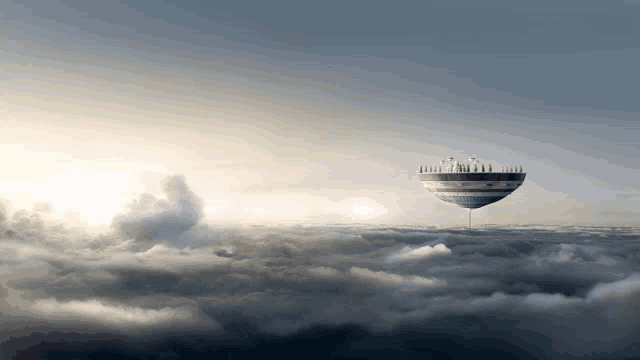 a hot air balloon floating in the clouds with a tower on top