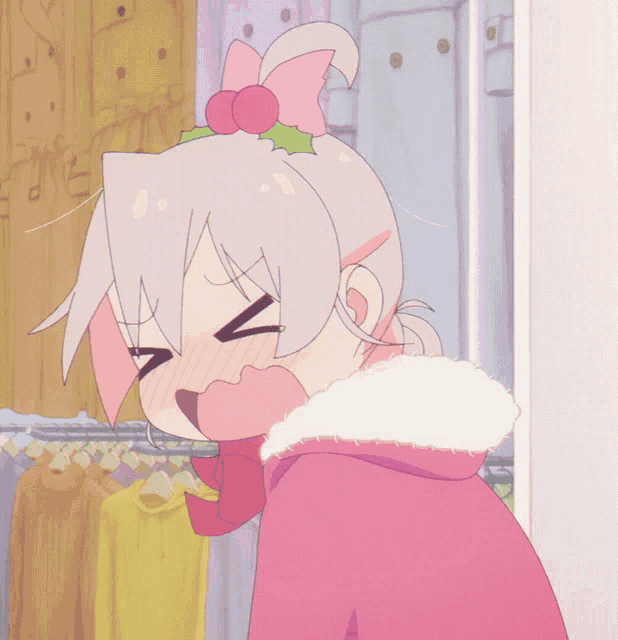 a girl with a pink bow on her head is standing in front of a rack of clothes