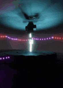 a person is standing in a dark room surrounded by lights