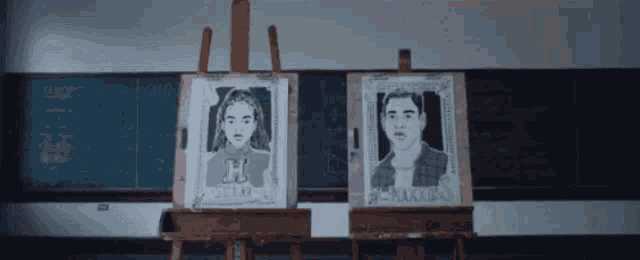 two paintings of a girl and a boy are on easels in front of a chalkboard