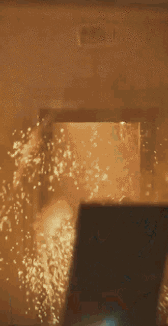 a person is standing in a room with a lot of sparks coming out of it