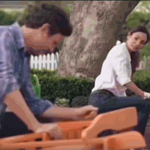 a man and a woman are sitting on a bench in front of a tree