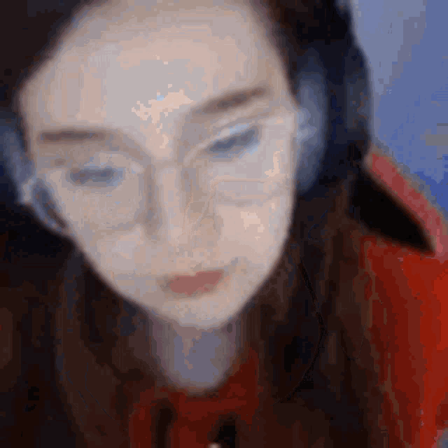 a woman wearing glasses and headphones is looking down at the camera .