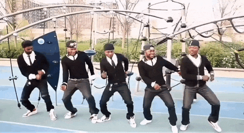 a group of men are dancing in a park