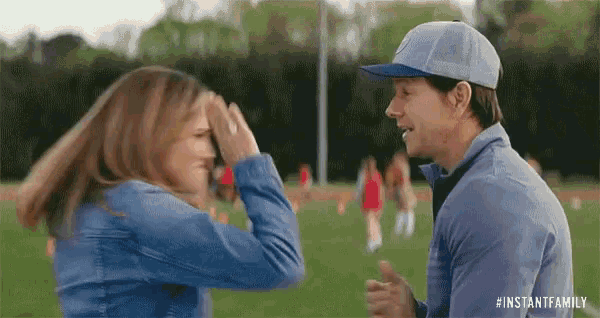 a man and a woman are touching their foreheads on a field .