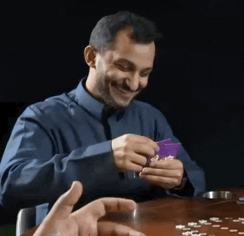 a man is smiling while playing a game of cards .