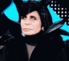 a close up of a woman wearing a black costume with horns on her head .