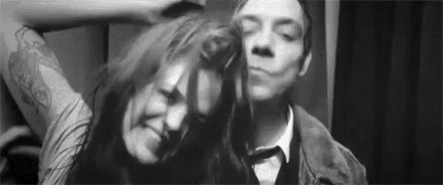 a man and a woman are standing next to each other in a black and white photo .