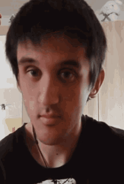 a close up of a person 's face with a black shirt