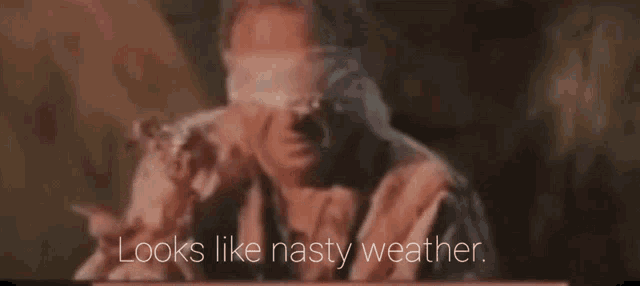 a blindfolded man with the words looks like nasty weather behind him