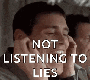 a man is covering his ears with his hands while talking on a phone .