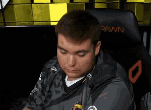 a man sitting in a chair with the word pawn on it