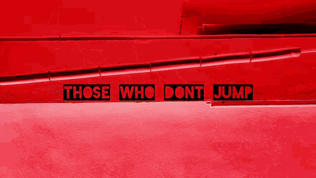 a red wall with a sign that says those who dont jump
