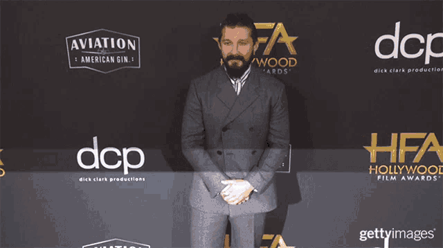 a man is standing in front of a wall that says dcp and hfa hollywood film awards