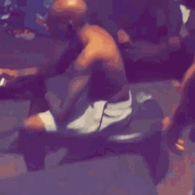 a man without a shirt is laying on a couch with his legs crossed .