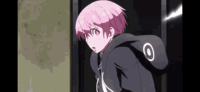 a girl with pink hair is wearing a black hoodie with a white circle on it .