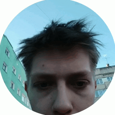 a close up of a person 's face in a circle with a green building in the background
