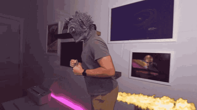 a man wearing a monster mask stands in front of a wall with posters on it including one that says ' space '