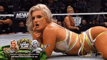 a woman in a wrestling ring with a sign that says aew grand slam australia