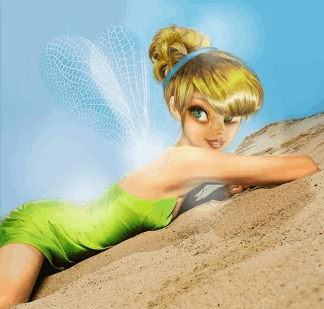 a fairy in a green dress is laying on a sandy beach