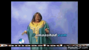 a woman in a green and yellow dress stands in front of a blue background with the website damaashad.com written on it
