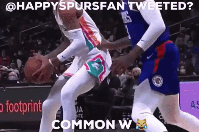 a basketball player is dribbling the ball while another player tries to block him