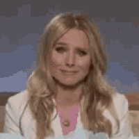 a woman is smiling and looking at the camera while sitting on a couch .