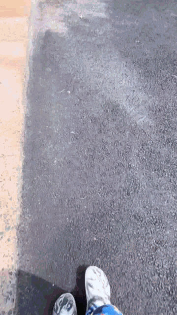a man in a blue shirt is walking on a sidewalk