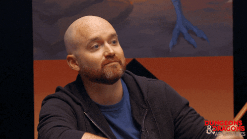 a bald man with a beard is sitting in front of a sign that says dungeons & dragons adventures