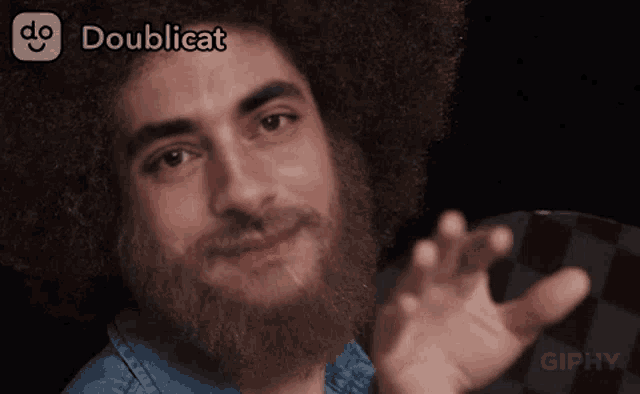 a man with a beard and an afro says doublicat on the bottom right