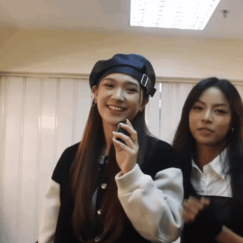 two women are standing next to each other and one is wearing a beret
