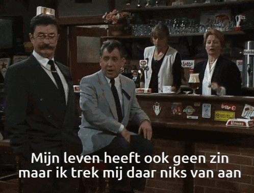 a woman sits at a table with a dog and says " mijn leven heeft ook geen zin maar ik trek mij daar niks van aan