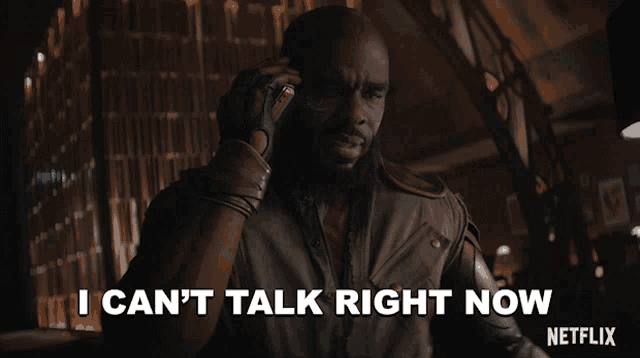 a man talking on a cell phone with the words " i can 't talk right now " on the bottom