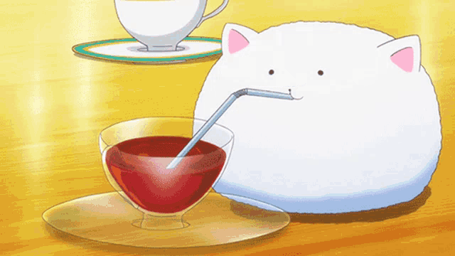 a white cat drinking from a glass with a straw in it