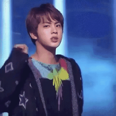 a close up of a person wearing a black jacket and a colorful shirt on a stage .