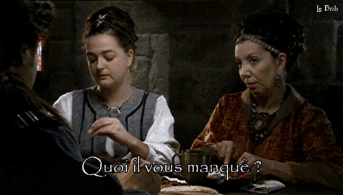 two women sitting at a table with the words " quoi il vous manque " written on the bottom