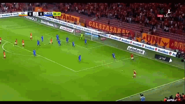 a soccer game is being played in a stadium with a galatasaray banner in the background