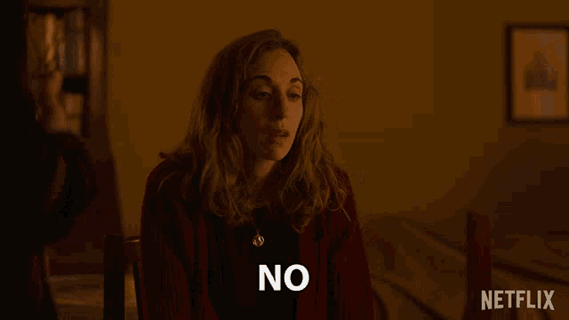 a woman sitting at a table with netflix written on the bottom of the screen