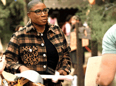 a woman wearing glasses and a plaid shirt is holding a piece of paper