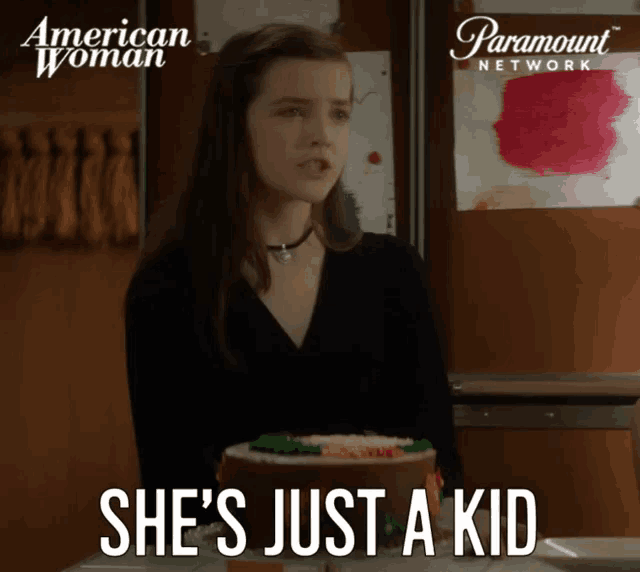 a paramount network ad for american woman shows a girl standing next to a cake