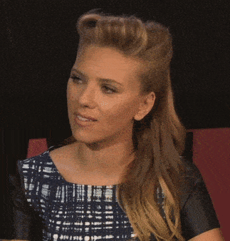 a woman with her hair in a ponytail is wearing a plaid shirt and black leather sleeves