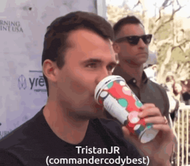 a man drinking from a cup with the name tristan jr written on it