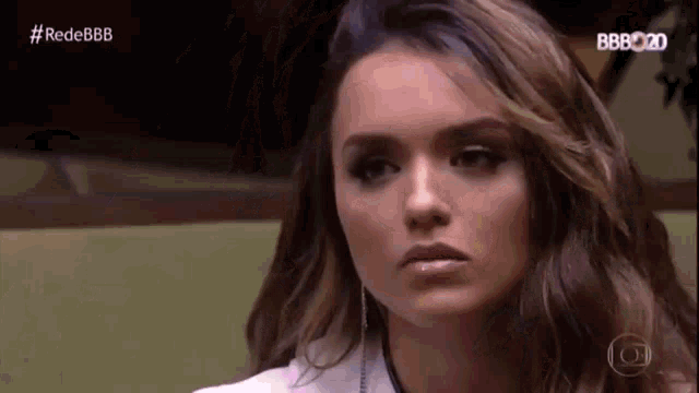 a close up of a woman 's face with a serious expression on her face .