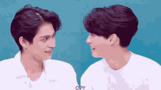 two men are looking at each other with their eyes closed and smiling .