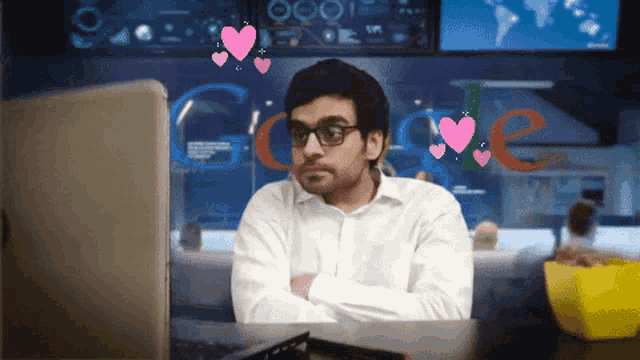 a man sitting in front of a laptop with hearts coming out of his head and the word google in the background