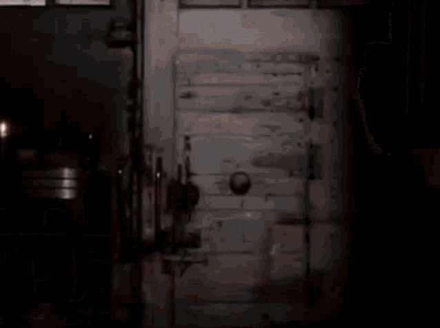 a man is holding a flashlight in a dark room with candles