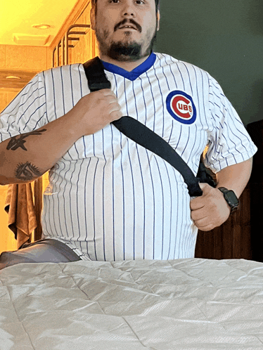 a man wearing a cubs jersey adjusts his shirt