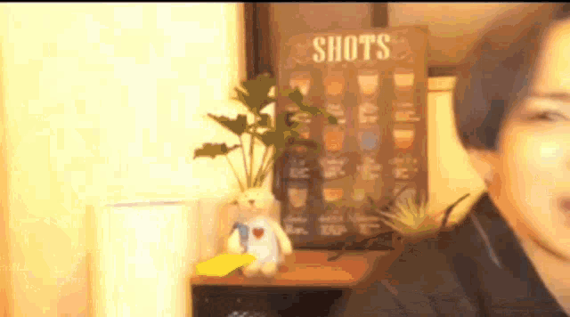 a woman is standing in front of a sign that says shots on it